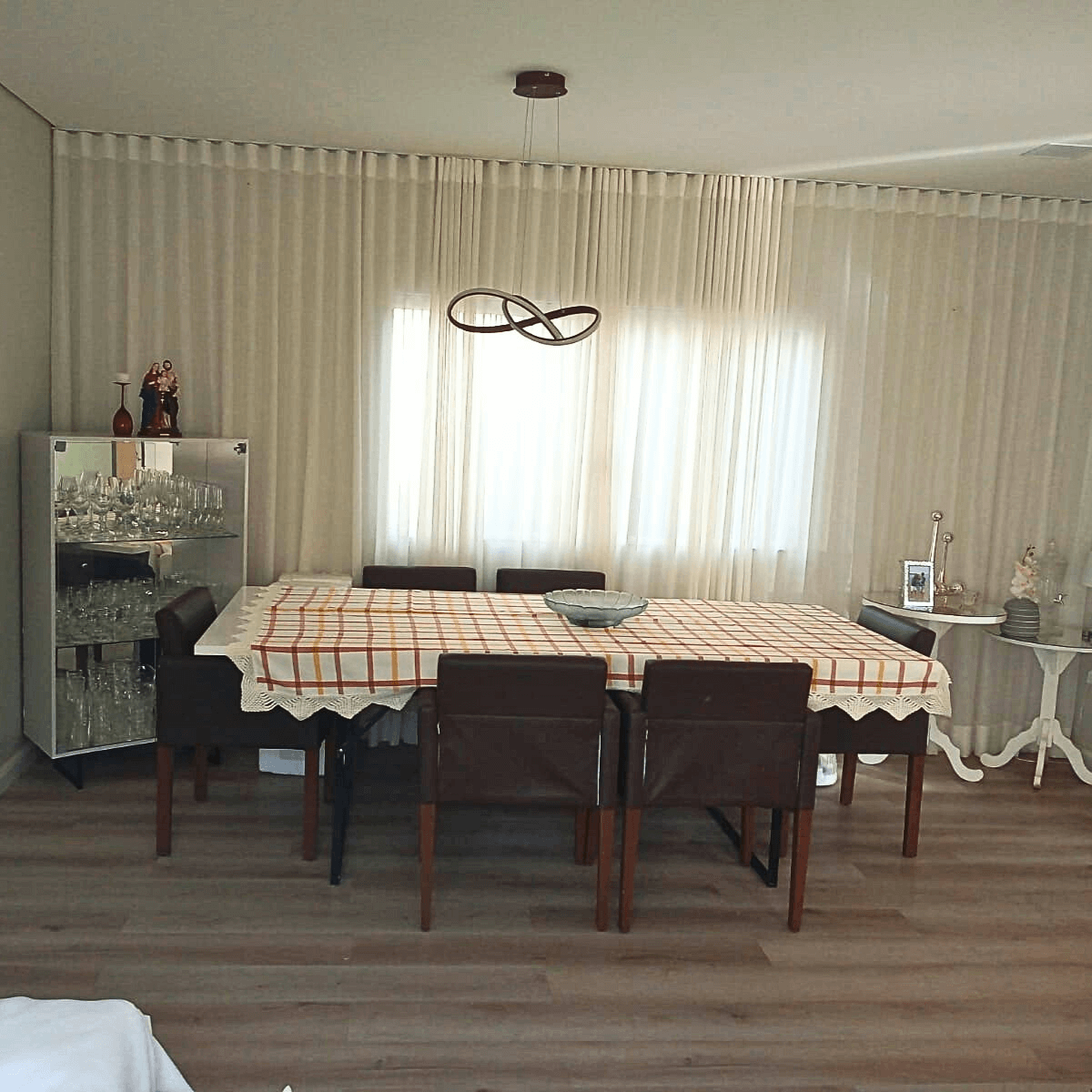 Sala de jantar decorada com mesa posta e piso laminado padrão madeira instalado por Tecfloor.