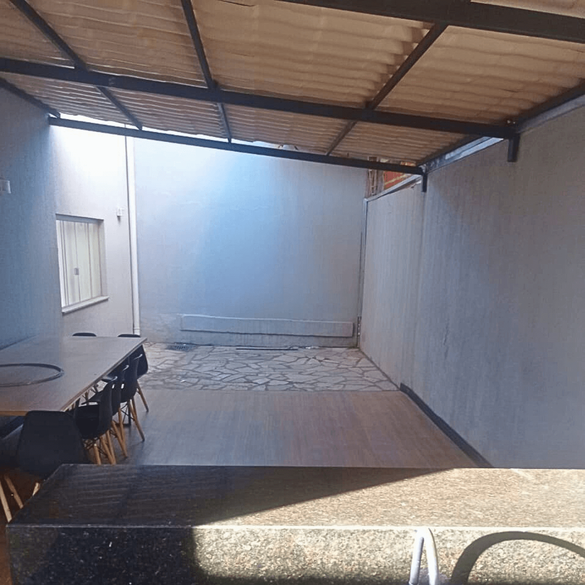 Reforma de área externa coberta com preparação de contrapiso e pintura de muros.