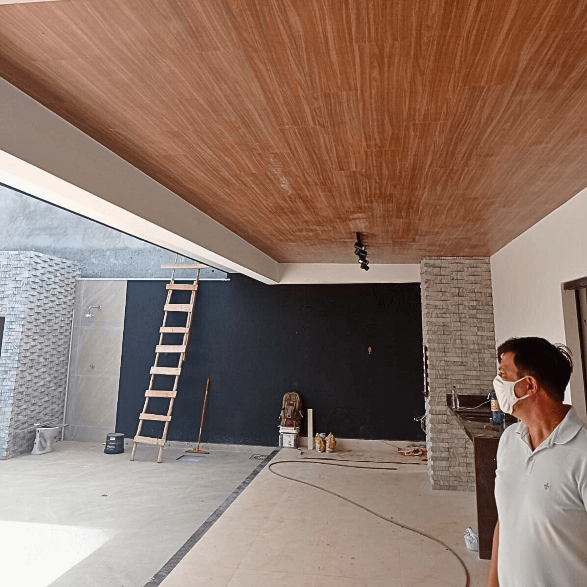 Equipe especializada realizando reforma de teto e acabamento de paredes em área gourmet.