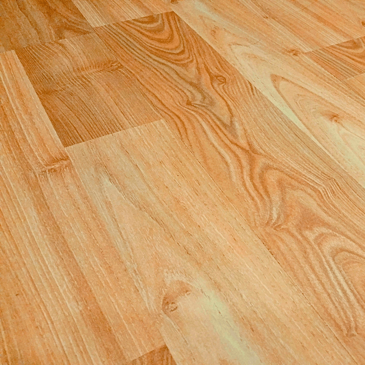 Close na textura de piso laminado cor marfim, destacando os veios realistas da madeira.